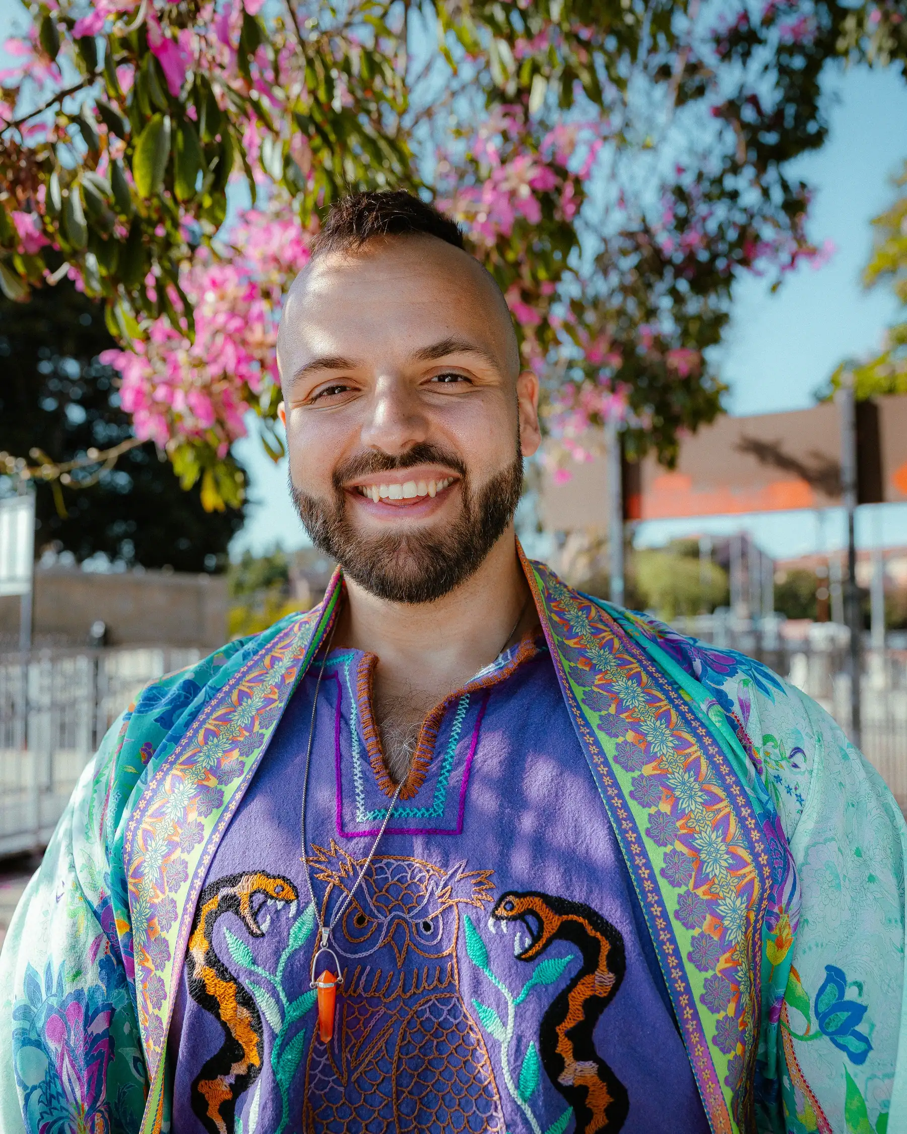 SANTOS wearing a purple owl shirt and colorful robe