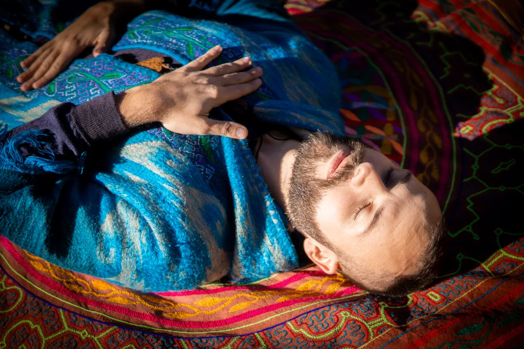 SANTOS resting in a blue cloak with a hand over his heart