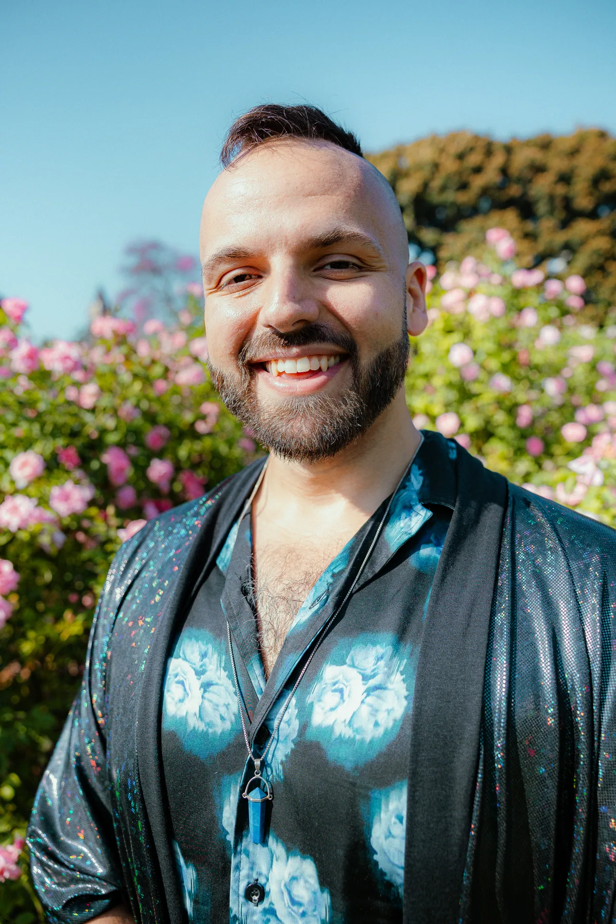 SANTOS in a dark blue shirt among roses