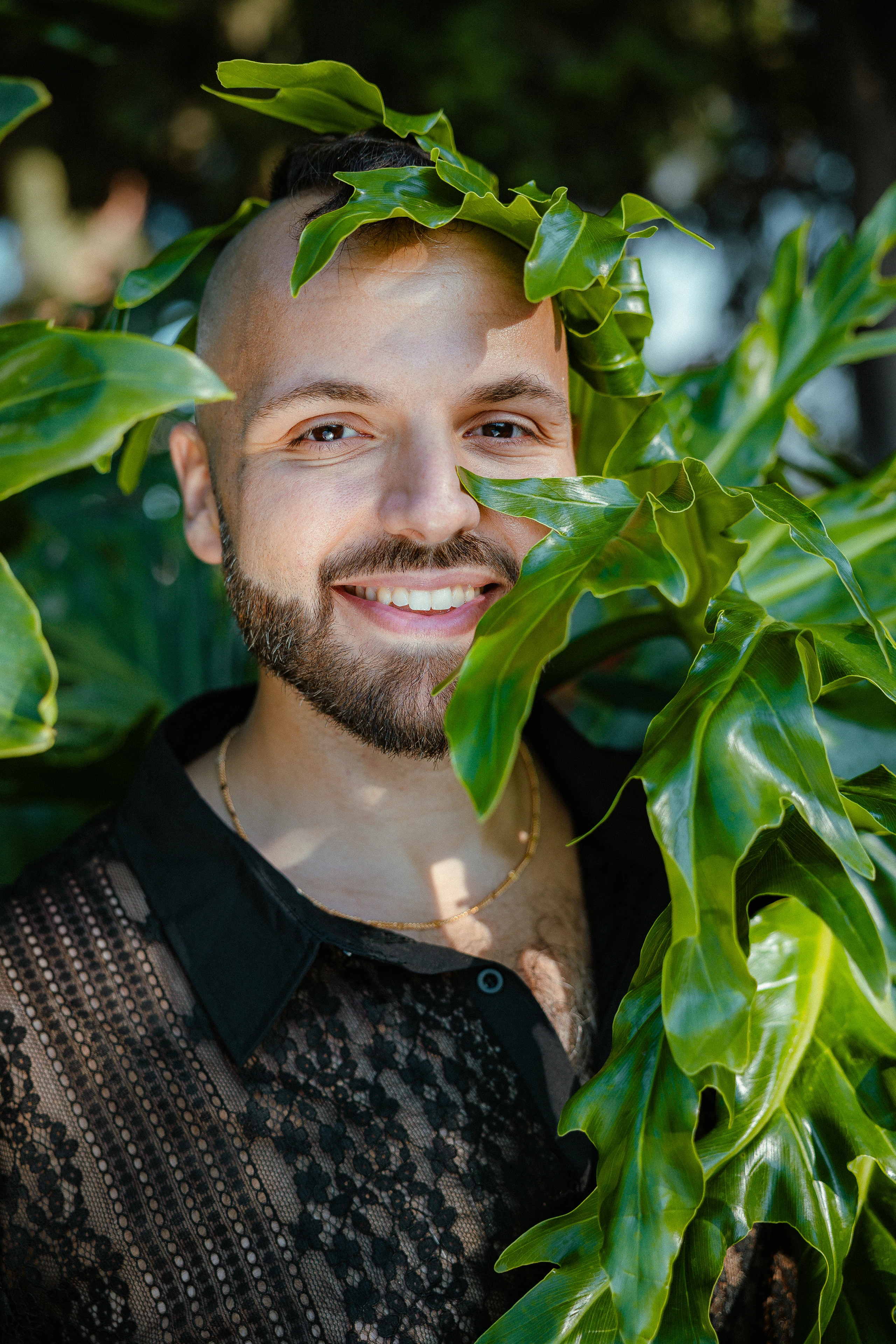 SANTOS in a black shirt framed by green leaves