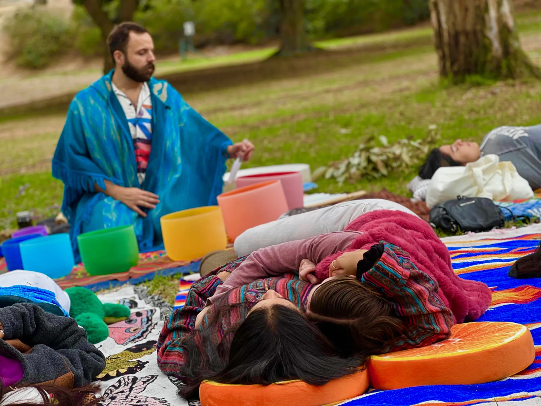 SANTOS leading a sound bath beneath the trees